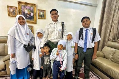 Mohd Hazley (tengah) bersama lima daripada enam anaknya yang bersekolah pada sesi persekolahan tahun ini.