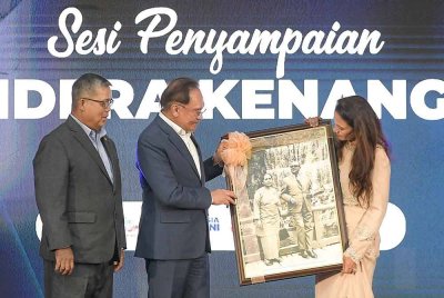 Perdana Menteri Datuk Seri Anwar Ibrahim menyampaikan gambar kenangan Tunku Abdul Rahman Putra Al-Haj dan isteri Tun Sharifah Rodziah Syed Alwi Barakbah, yang dirakam di kawasan Chinzanso Restaurant, Tokyo, Jepun, pada 30 Julai 1970, kepada cucu Tunku Abdul Rahman, Datin Seri Sharifah Menyalara Hussein (kanan) semasa Majlis Memperingati Bekas Perdana Menteri Malaysia Pertama, di Memorial Tunku Abdul Rahman, Jalan Dato' Onn pada Isnin. Foto Bernama