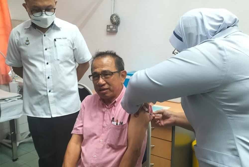 Daniel Gooi memantau pemberian vaksin influenza di Klinik Kesihatan Jalan Macalister pada Selasa.