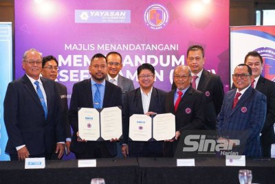 Ewon (tengah) menyaksikan sesi pertukaran dokumen perjanjian antara Yayasan Bank Rakyat (YBR) dan Universiti Keusahawanan Koperasi Malaysia (UKKM) di Menara Bank Rakyat pada Selasa. Foto SINAR HARIAN / MOHD HALIM ABDUL WAHID