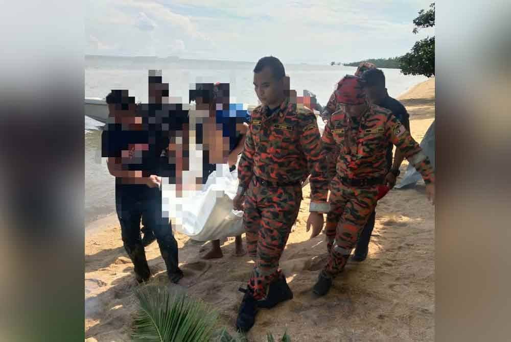 Anggota bomba mengangkat mayat mangsa untuk diserahkan kepada pihak polis.
