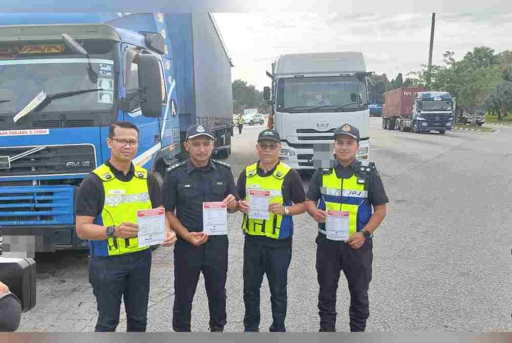 (Dari kiri) Suhairy, Amir, Mohd Yusof dan Nor Zulhairi menunjukkan risalah perluasan larangan pergerakan kenderaan berat pada waktu puncak.