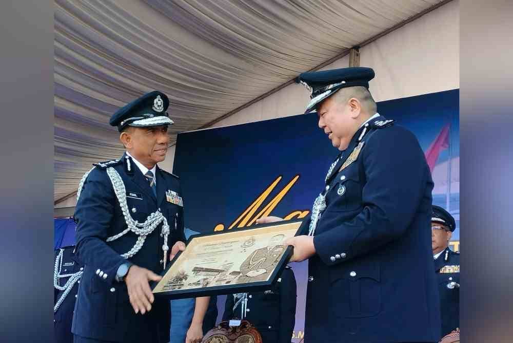 Ketua Polis Kedah, Datuk Fisol Salleh (kiri) menyampaikan cenderahati kepada Kok Chin.