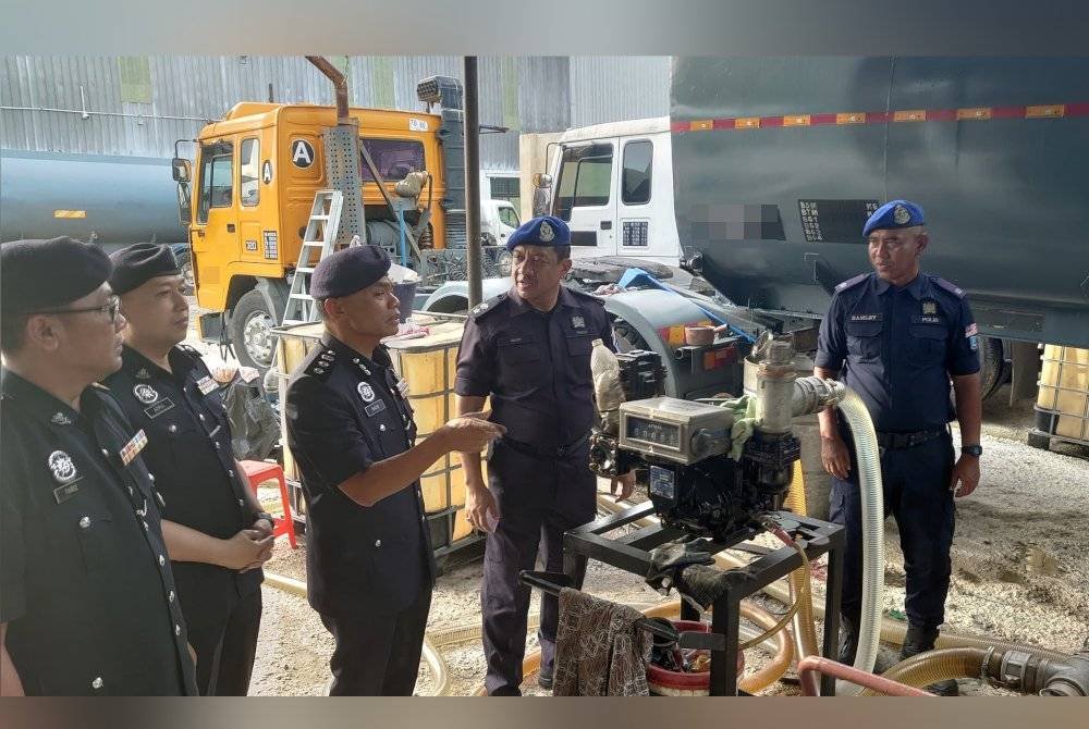 Raub (tengah) menunjukkan pam elektrik yang dirampas dalam serbuan pada Selasa.