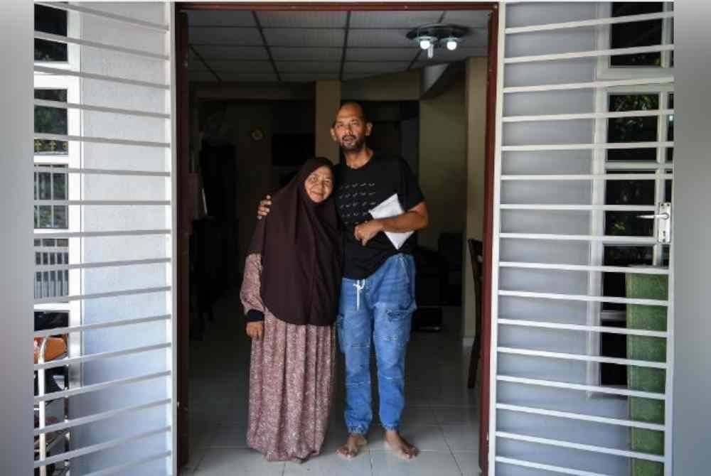 Muhammad Sufi bersama ibunya, Nooraini Ishak,71 menerima sumbangan Perdana Menteri, Datuk Seri Anwar Ibrahim yang diwakili di rumahnya di Taman Jitra Indah hari ini. Foto Bernama