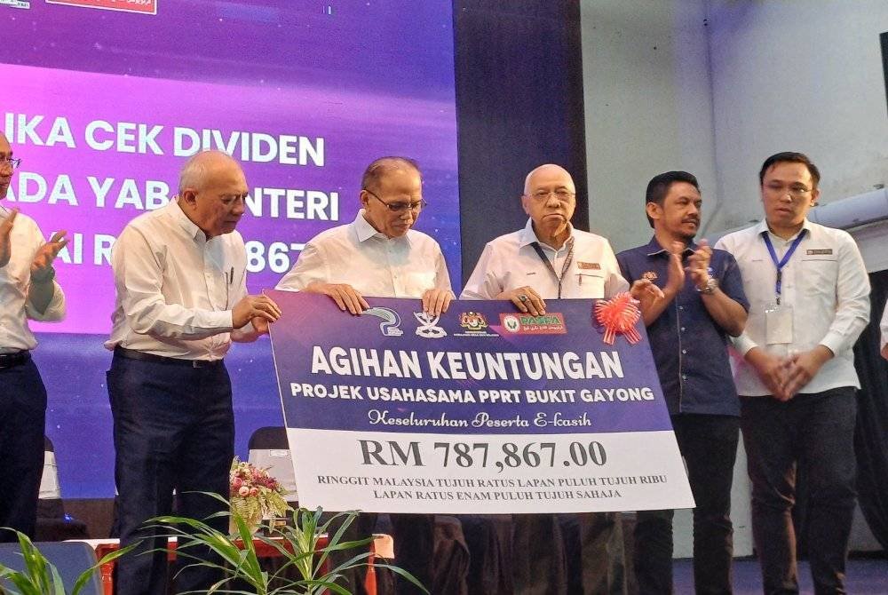 Wan Rosdy menerima replika cek pada majlis penyerahan dividen Ladang Usahasama Integrasi Lembu dan Sawit PPRT Ladang Bukit Gayong, yang disalurkan kepada peserta e-Kasih Pasfa pada Rabu.