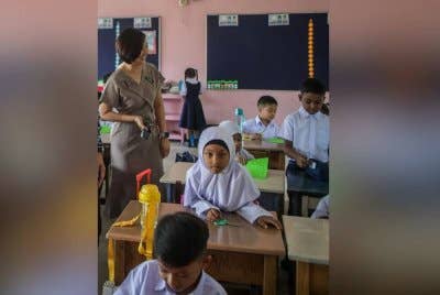 Yong Siang beramah mesra dengan murid Tahun Satu SKJC Kong Aik pada hari pertama sesi persekolahan di Perlis pada Isnin.