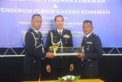 Mohd Khairi (tengah) menyaksikan majlis serah terima tugas oleh Pemangku Ketua Polis Daerah Kemaman, Superintenden Wan Muhamad Wan Ja'afar (kiri) kepada Superintenden Mohd Razi (kanan) di Ibu Pejabat Polis Daerah (IPD) Kemaman pada Rabu.