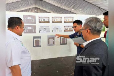 Hilmi (kiri) mendengar penerangan berhubung perkembangan persediaan tapak Madinan Radaman.