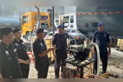 Raub (tengah) menunjukkan pam elektrik yang dirampas dalam serbuan pada Selasa.