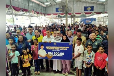 Syed Abu Hussin (tengah) bersama sebahagian penerima sumbangan sempena Majlis Penyampaian Bantuan Kembali Ke Sekolah di Pusat Khidmat Parlimen Bukit Gantang pada Rabu.