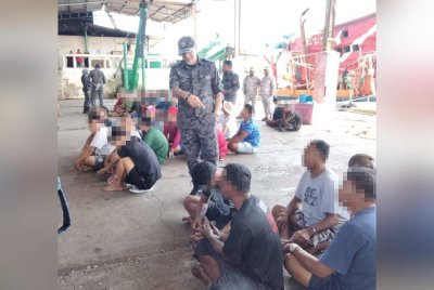 Mohamed Yusoff Khan (berdiri) bertanya sesuatu kepada Mat (duduk, kiri) yang ditahan dalam operasi pada Rabu.