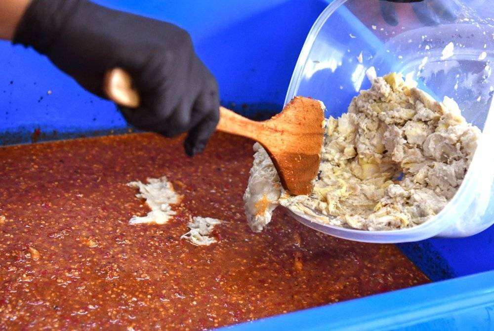 Ibnu Sina menunjukkan cara penghasilan 'Sambal Budu Durian' yang menjadi kegemaran pelanggan ketika ditemui di kediamannya dekat Kampung Bunut Payong. Foto Bernama
