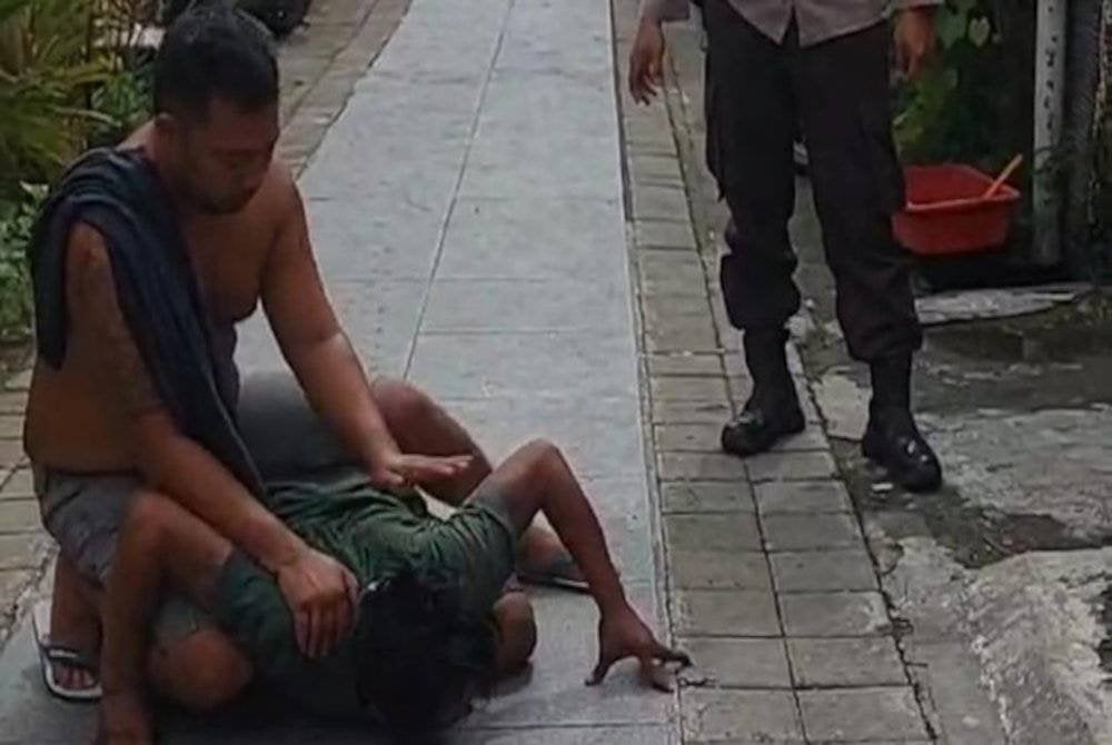 Lelaki itu merangkak seperti buaya di depan rumahnya. Foto Agensi