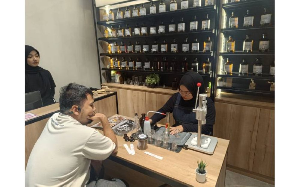 Nurul Ain Najwa sedang menghasilkan minyak wangi yang menjadi permintaan di kedai Luxe By Simply Famous.