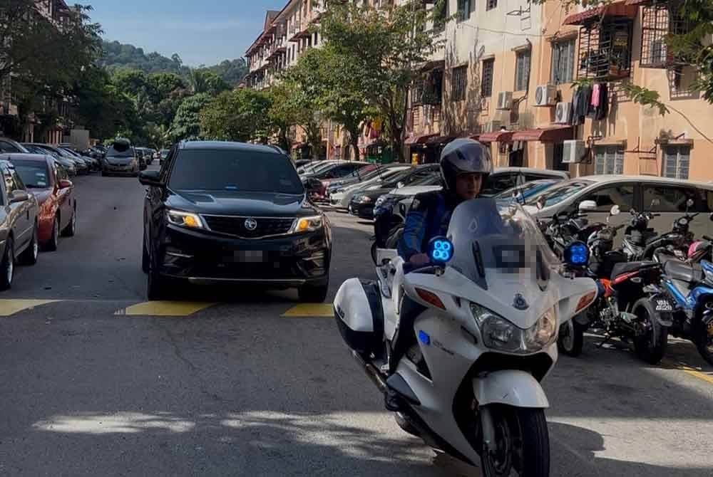 Kelihatan kenderaan yang diiringi polis memasuki kawasan Apartmen Idaman di Damansara Damai.