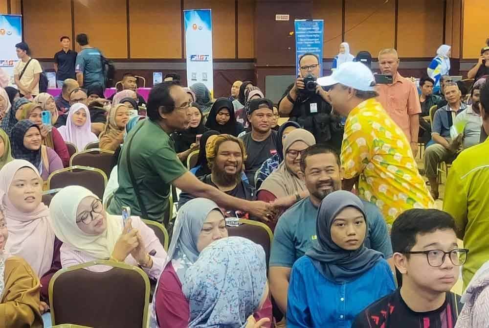 Abdul Gafar (kanan) beramah mesra dengan peniaga pada taklimat kepada peniaga tapak bazar Ramadan di Dewan MBAS, Alor Setar pada Khamis.