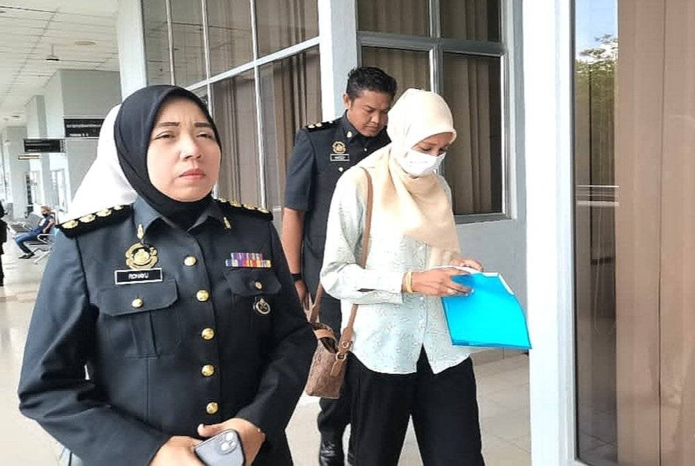 Norfamieza diiring pegawai KPDN ketika hadir ke mahkamah pada Khamis.