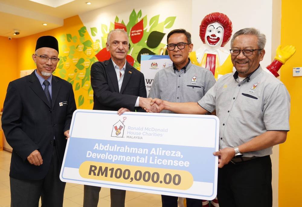 Abdulrahman (dua dari kiri) menyerahkan sumbangan RM100,000 kepada RMHC Malaysia.