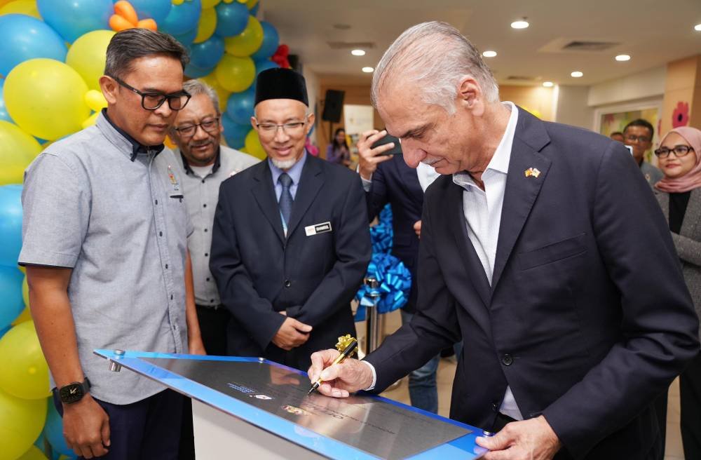 Abdulrahman (kanan) menandatangani plak perasmian yang disaksikan oleh Shamsul, Nasri dan Azmir.