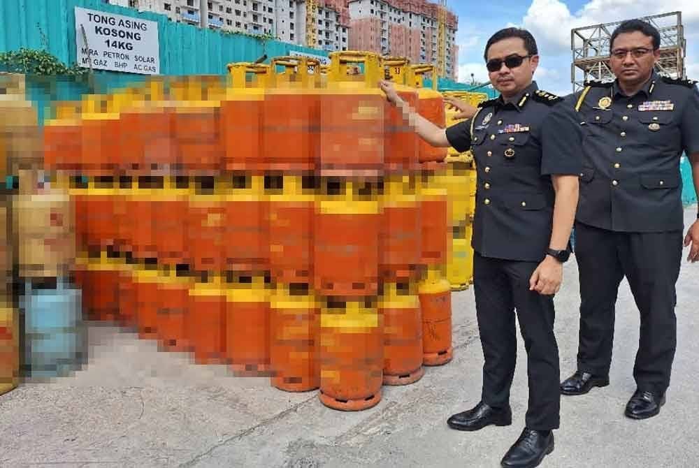 Mohd Zuhairi menunjukkan tong gas yang disita di sebuah premis di Taman Meranti Permai, Puchong pada Rabu.