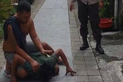 Lelaki itu merangkak seperti buaya di depan rumahnya. Foto Agensi