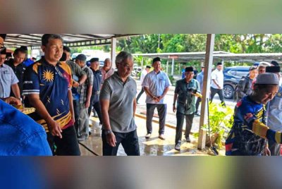 Al-Sultan Abdullah (tengah) berkenaan berangkat mencemar duli menyantuni mangsa banjir di PPS SMK Karak Setia, Bentong pada Khamis.