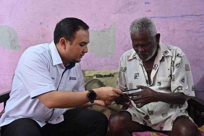 Ahmad Farhan (kiri) mewakili Perdana Menteri menyampaikan sumbangan wang tunai dan bakul makanan kepada Ramaiyeyah bagi meringankan beban warga emas itu - Foto: FB Anwar Ibrahim