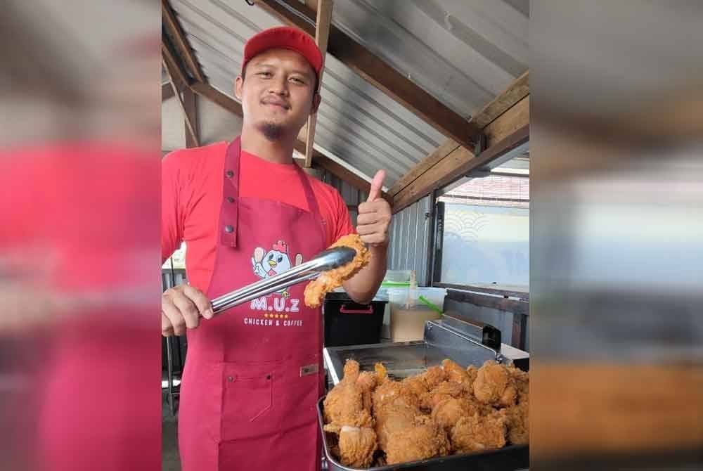Alang sedang mengoreng ayam yang sudah diadun dengan tepung aduan di gerainya di Tanjung Lumpur. Foto Sinar Harian.