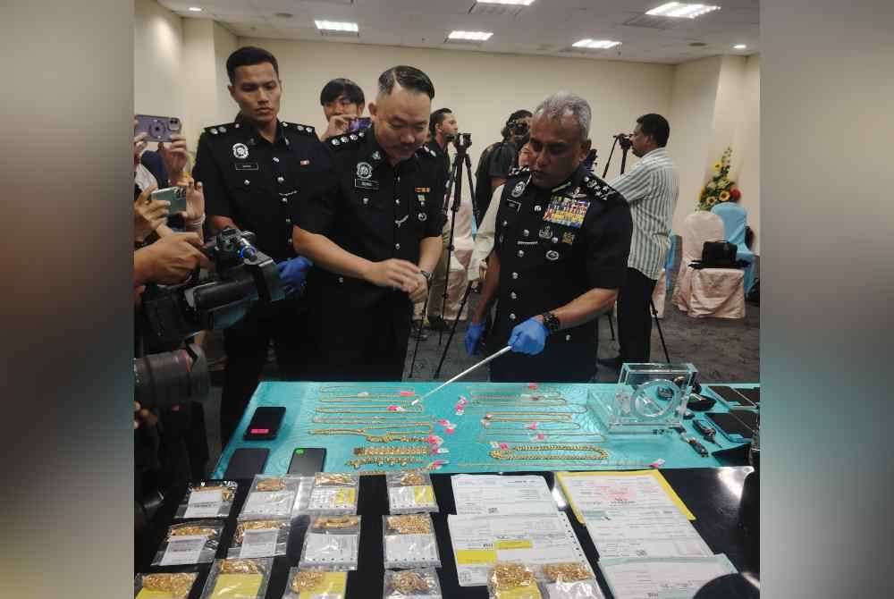 Ramli (kanan) menunjukkan barang kemas yang dirampas susulan penahanan tiga pekerja kedai emas di Sungai Buloh, Selangor, 6 Februari lalu.