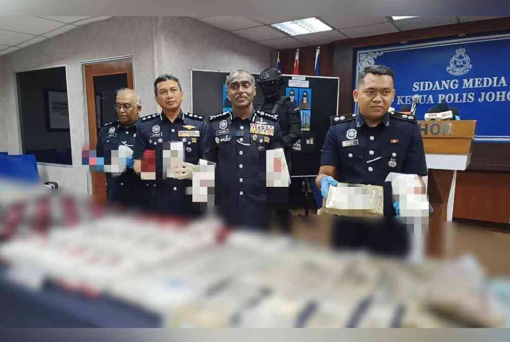 Kumar (dua dari kanan) menujukkan rampasan pelbagai jenis dadah selepas tiga individu termasuk seorang wanita diberkas dalam serbuan di empat lokasi sekitar Johor Bahru pada minggu lalu.