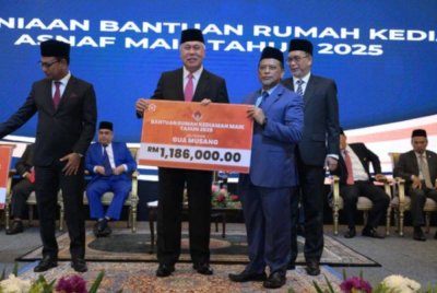 Tengku Muhamad Rizam (kiri) menyampaikan plakad Bantuan Rumah Kediaman MAIK kepada Ketua Jajahan Gua Musang, Rusydee Abdullah. 