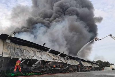 Pasukan bomba memadamkan kebakaran di lokasi kejadian.