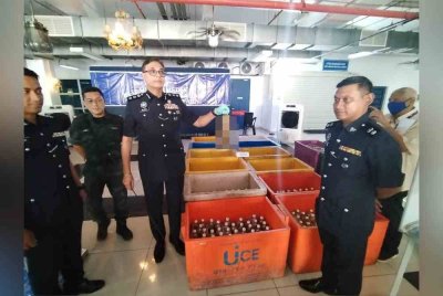 Balveer (tiga, kiri), menunjukkan kotak berisi air ketum yang dirampas.