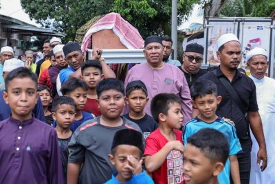 Anggota keluarga mengusung jenazah Allahyarham Mohammad Fahmi Hafiz Mohammad Fakhruddin untuk dikebumikan di Tanah Perkuburan Islam Kampung Permatang Binjai pada Jumaat. Foto Bernama