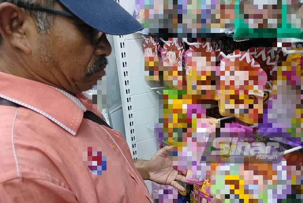 Adnan (kanan) mendapati gula-gula 'gummy eyeball' tidak lagi dijual di beberapa premis perniagaan di daerah ini.