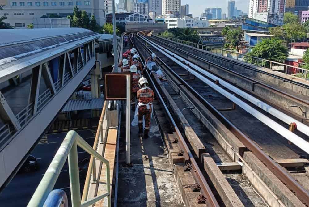 Pasukan bomba membawa keluar mayat mangsa yang terjatuh di rel stesen LRT Titiwangsa, Kuala Lumpur pada Sabtu. Foto: Bomba Kuala Lumpur.