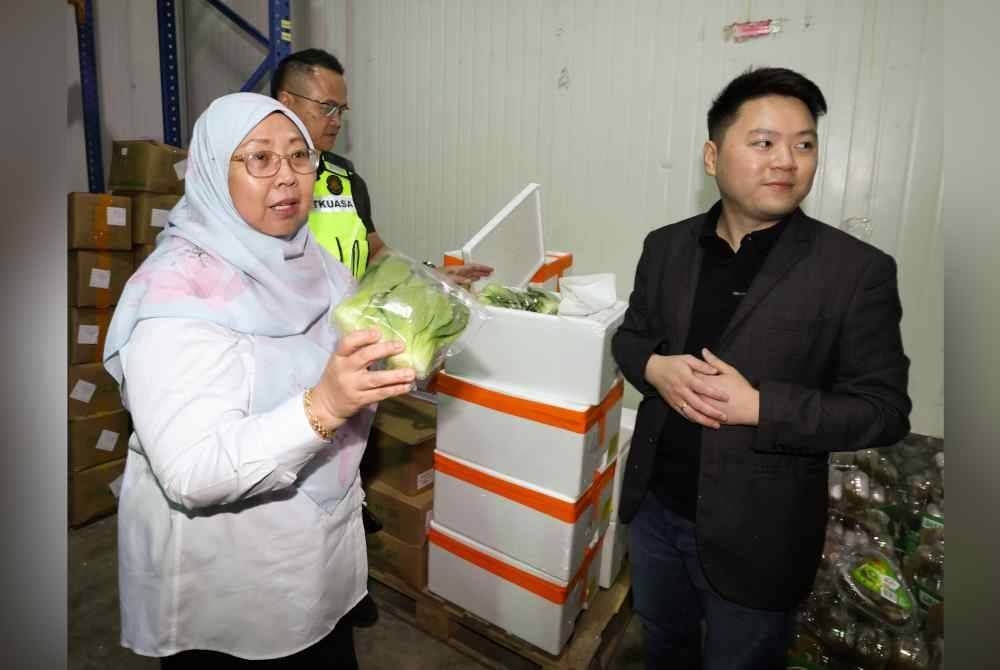 Fuziah Salleh (kiri) melihat sayuran segar pada lawatan ke sebuah gudang pemborong sempena Program Turun Padang Penguatkuasaan KPDN Sarawak hari ini. - Bernama