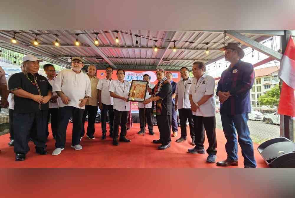 Pandikar (tiga dari kanan) menerima cenderahati selepas menyempurnakan program Jelajah USNO Peduli Rakyat Zon 3 di dewan Kampung Warisan, Inanam.