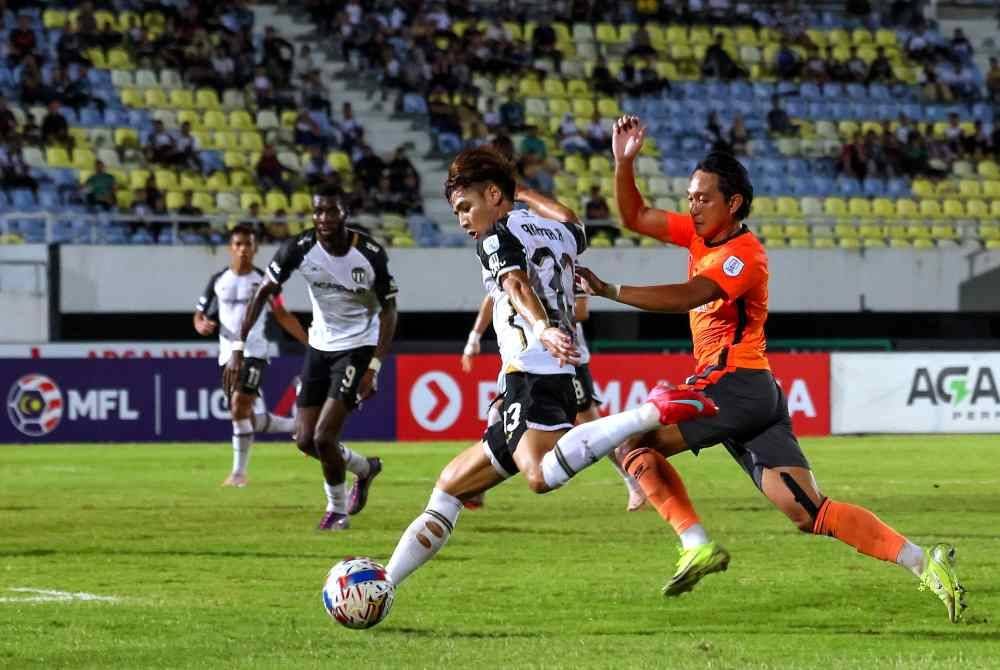Tonggak Terengganu, Akhyar Rashid (dua dari kanan) diasak pemain Kuching City pada saingan Liga Super di Stadium Sultan Mizan Zainal Abidin, Gong Badak pada Jumaat.
