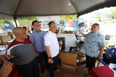 Rais (kanan) melihat sebahagian barang kitar semula pada Program Anda Kitar, Kami Bayar Perdana 100 tan kilogram Kitar Semula Komuniti Lestari di Dataran MBMB Ayer Keroh pada Sabtu.