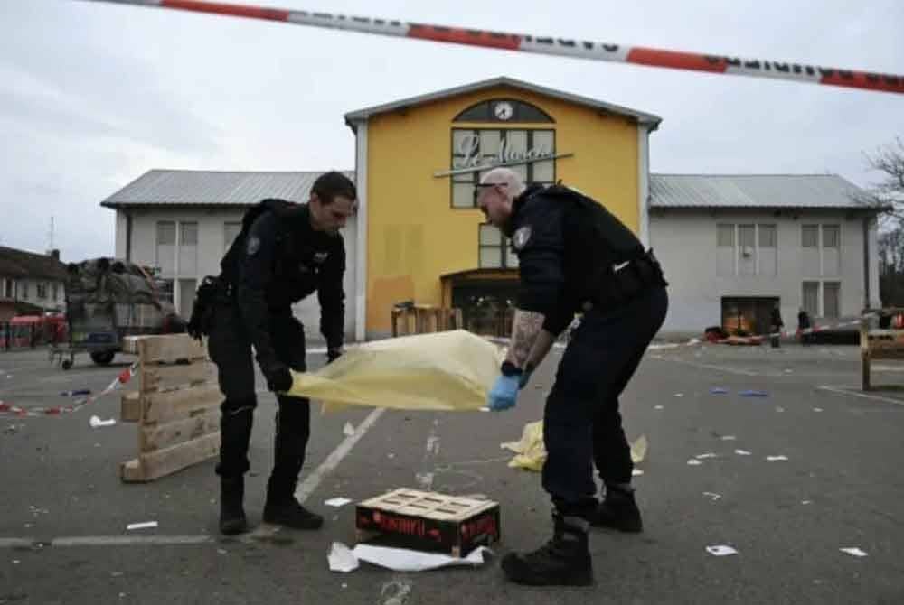 Anggota polis perbandaran Perancis mengumpul bukti di dataran pasar Mulhouse selepas kejadian tikaman. Foto AP