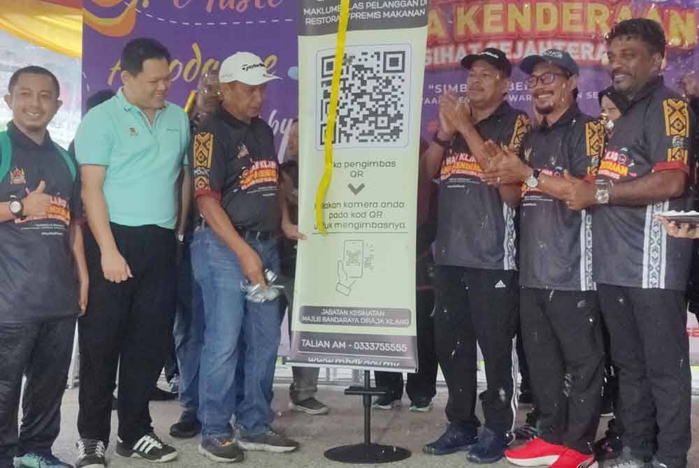 Mohammed Khusrin (tiga dari kiri) melakukan gimik perasmian pelancaran kod respons pantas (QR) restoran sempena Hari Klang Tanpa Kenderaan pada Ahad.