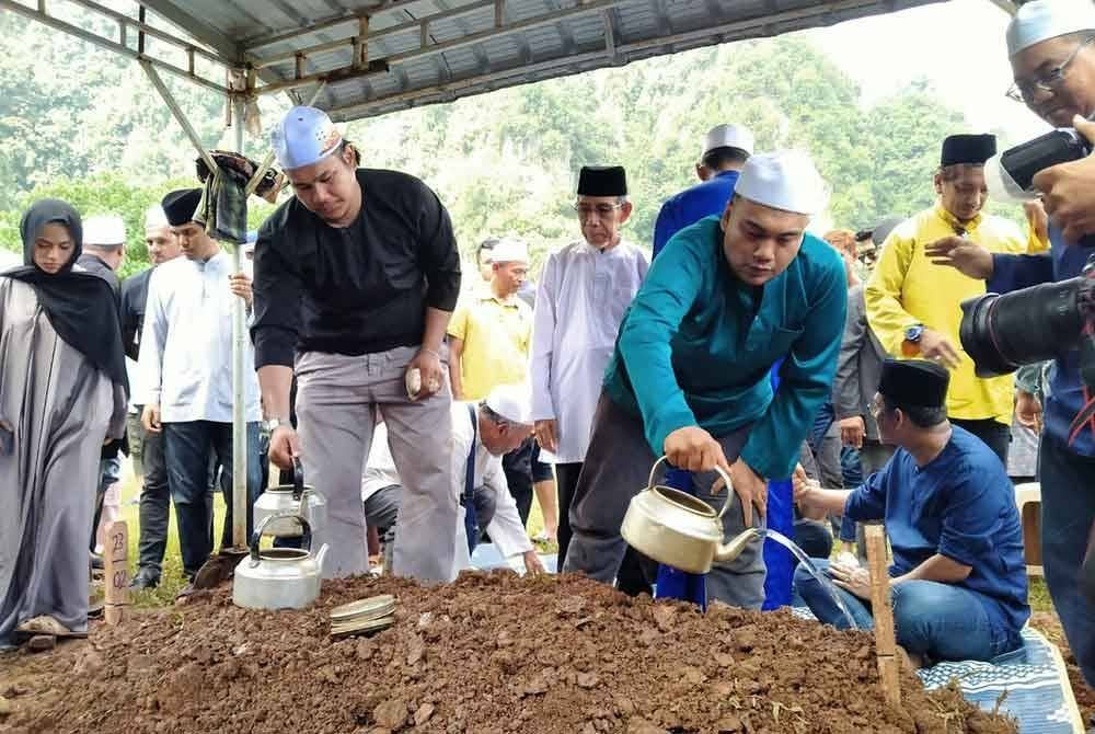 Anak sulung Allahyarham, Muhammad Iszul Imadi, 32, menyiram pusara Ishsam di Tanah Perkuburan Islam Rapat Setia di sini pada Ahad.