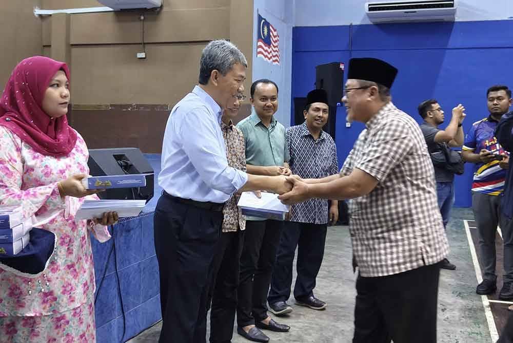 Mohamad (dua kanan) menyampaikan sumbangan imarah masjid dan surau sempena Ramadan.
