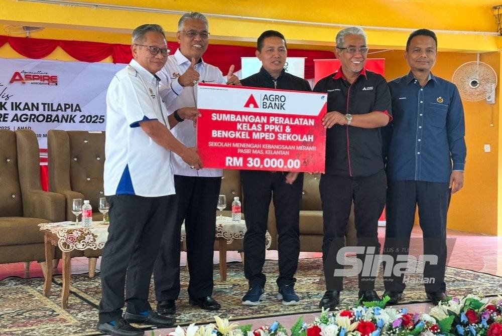 Ahmad Badli Shah (dua dari kanan) menyerahkan replika cek kepada Pengetua SMK Meranti, Pengetua SMK Meranti, Mohammad Razuki Derahman (kiri). FOTO SINAR HARIAN-ADILA SHARINNI WAHID