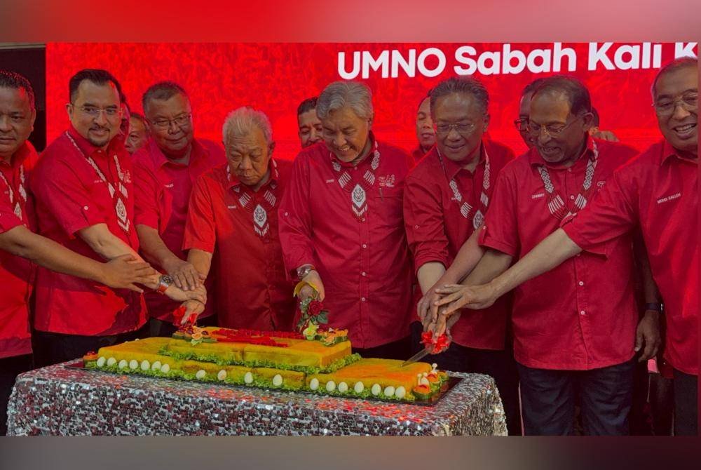 Ahmad Zahid (empat dari kanan) memotong kek sempena Majlis Ulang Tahun UMNO Sabah kali ke-34 di Kompleks Sukan Tawau.