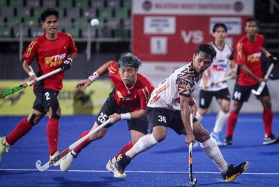 Pemain THT, Faizal Saari (kanan) cuba merampas bola dari pemain pasukan hoki Tenaga Nasional Berhad (TNB) Jang Jong Hyun (kiri) pada aksi akhir Piala TNB Cup 2025 di Stadium Nasional Hoki Bukit Jalil. Foto Bernama