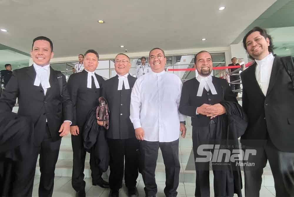 Sanusi (tiga dari kanan) tersenyum disamping barisan peguamnya, selepas Mahkamah Tinggi Shah Alam pada Isnin melepaskan dan membebaskannya daripada satu kes menghasut berkaitan Agong, dua tahun lalu.