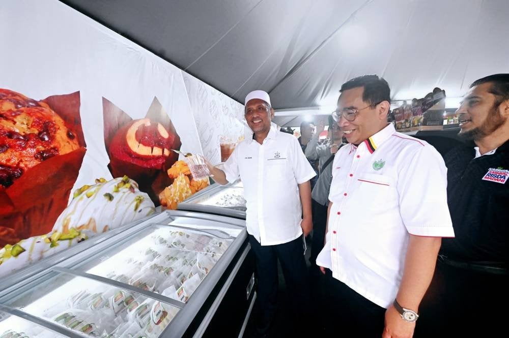 Syed Ibrahim ditemani Zainal melawat gerai usahawan selepas majlis perasmian Karnival RISDA Madani (KARRISMA) Zon Timur 2025 di pekarangan Stadium Darul Makmur, di sini, pada Sabtu.